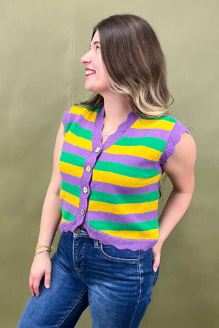 Woman wearing a colorful striped cardigan against a plain background