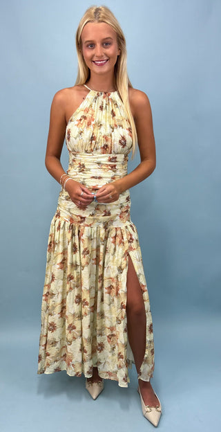 Woman wearing a floral dress with a slit on a light blue background
