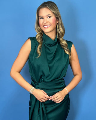Emerald green satin midi dress with a draped cowl neckline, sleeveless design, and flattering tie-waist detail.
