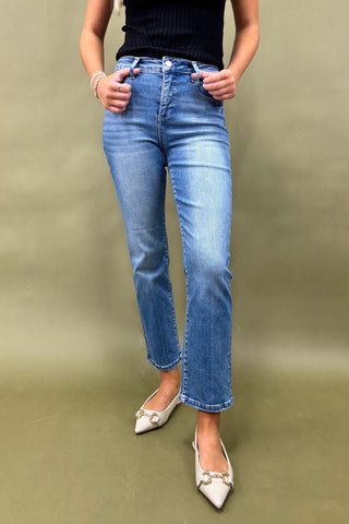 Person wearing blue jeans and white shoes on a green background