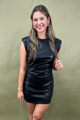 Woman wearing a black dress against a green background