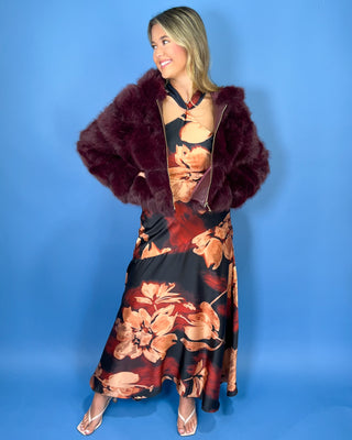 Burgundy faux fur cropped jacket with plush textured fabric, oversized collar, long sleeves, and gold zipper closure.
