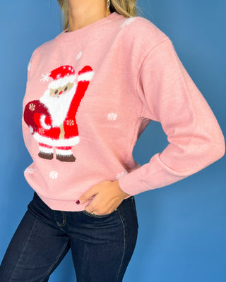 Pink Christmas knit sweater with Santa Claus graphic, white snowflake accents, crew neckline, long sleeves, and ribbed trim.