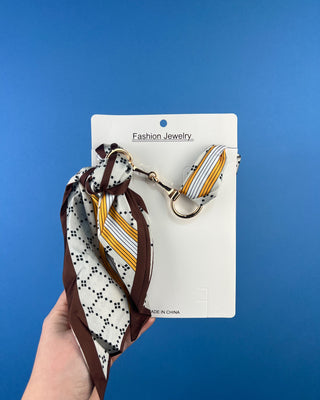 Shop the Horse Bit Scarf Necklace featuring elegant gold-tone hardware and a silky satin scarf. Available in multiple colors and stylish prints.