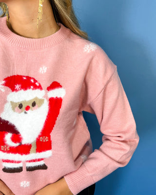 Pink Christmas knit sweater with Santa Claus graphic, white snowflake accents, crew neckline, long sleeves, and ribbed trim.