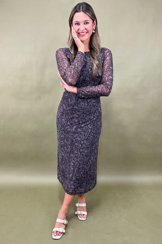 Woman wearing a patterned dress against a plain background