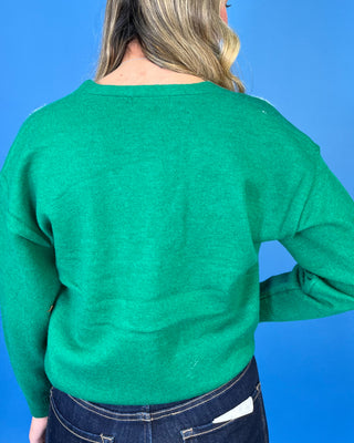 Green Christmas knit cardigan with V-neckline, button front, festive Santa and Christmas tree designs, and front pockets.