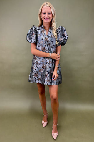 Woman wearing a floral dress against a plain background