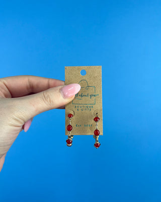 Shop the Rachel Red Stone Hoops featuring glossy red stones, polished gold-tone hoops, and delicate bead accents. Perfect for holidays and game days.