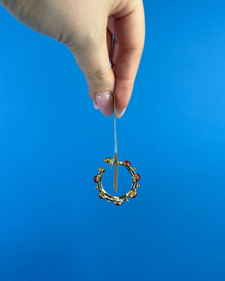 Shop the Rachel Red Stone Hoops featuring glossy red stones, polished gold-tone hoops, and delicate bead accents. Perfect for holidays and game days.