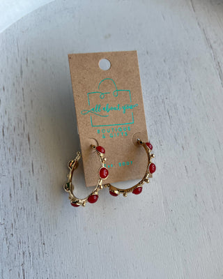 Shop the Rachel Red Stone Hoops featuring glossy red stones, polished gold-tone hoops, and delicate bead accents. Perfect for holidays and game days.