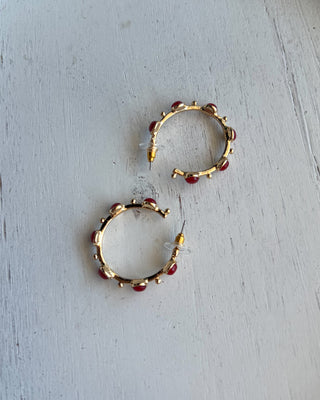 Shop the Rachel Red Stone Hoops featuring glossy red stones, polished gold-tone hoops, and delicate bead accents. Perfect for holidays and game days.