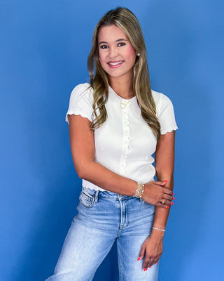 Woman wearing a white blouse and blue jeans against a blue background