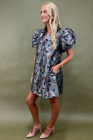 Woman wearing a floral dress against a green background