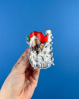 Shop the Santa Hair Clip featuring a pearlescent Santa design, pink heart sunglasses, and festive holiday details. A cute Christmas claw clip!