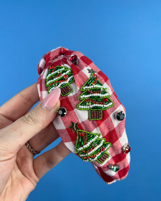 Shop the Red Gingham Christmas Headband featuring beaded Christmas trees, sparkling rhinestones, and a festive knotted design. Perfect for holiday outfits!