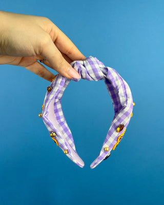 Shop the Purple Gingham Gameday Headband featuring sparkling purple and gold beaded paw prints, rhinestones, and a trendy knotted design. Perfect for game day!