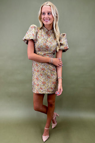 Woman wearing a floral dress against a green background