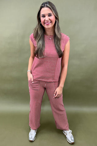 Woman wearing a red and white striped outfit against a green background