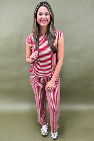 Woman wearing a red and white striped outfit against a green background