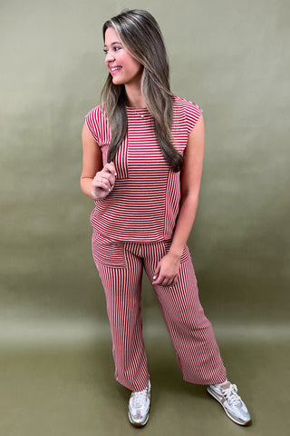 Woman wearing a red and white striped outfit against a green background