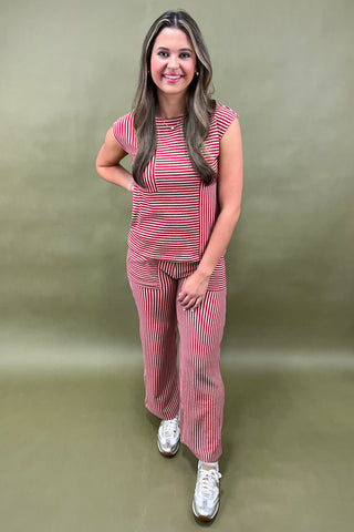 Woman wearing a red and white striped outfit against a green background