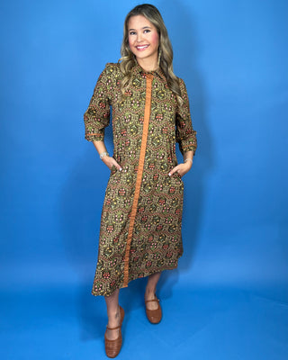 Olive floral print midi dress with contrast trim, three-quarter sleeves, button-front detail, and side pockets.