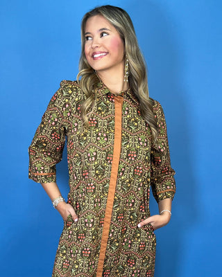Olive floral print midi dress with contrast trim, three-quarter sleeves, button-front detail, and side pockets.