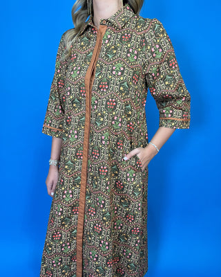 Olive floral print midi dress with contrast trim, three-quarter sleeves, button-front detail, and side pockets.