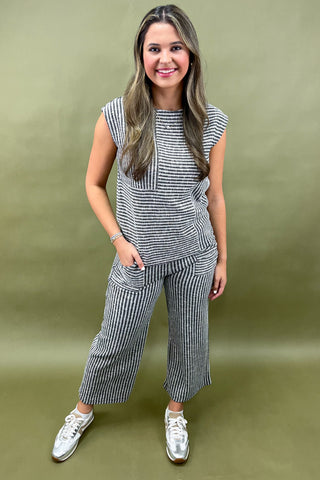Woman wearing a striped outfit against a green background