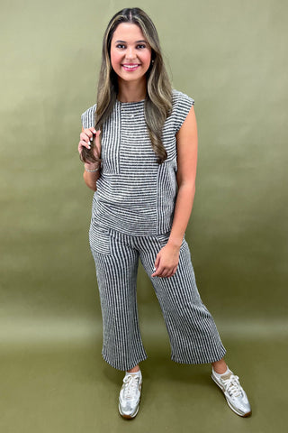 Woman wearing a striped outfit against a green background