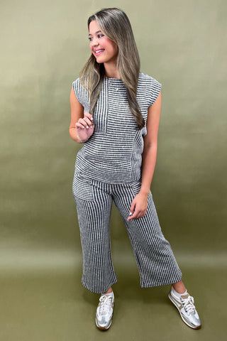 Woman wearing a striped outfit against a green background