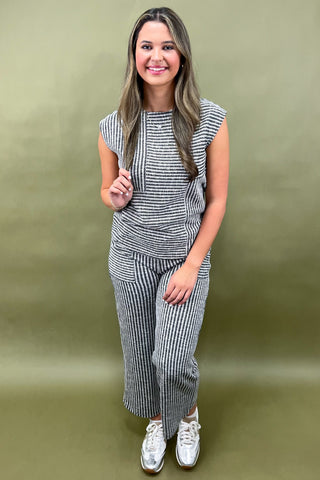 Woman wearing a black and white striped outfit against a green background