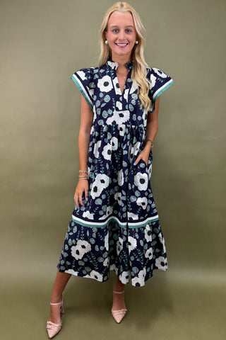 Woman wearing a navy floral dress against a green background