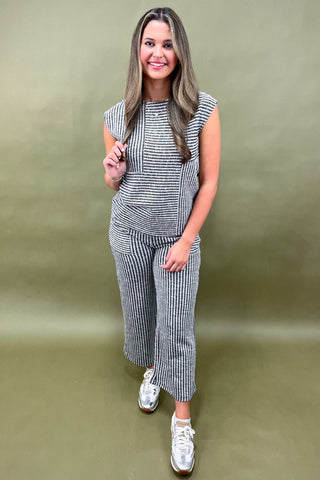 Woman wearing a striped outfit with a green background