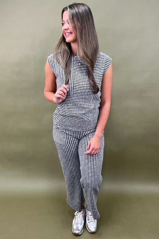 Woman wearing a striped outfit against a plain background