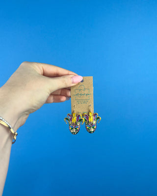 Shop the Jester Mardi Gras Earrings featuring glittery purple, green, and gold jester masks. Perfect for Mardi Gras parades, Fat Tuesday, and festive outfits.