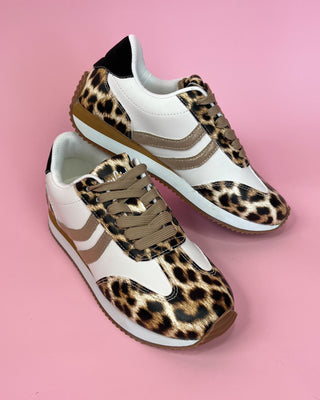Pair of sneakers with leopard print pattern on a pink background