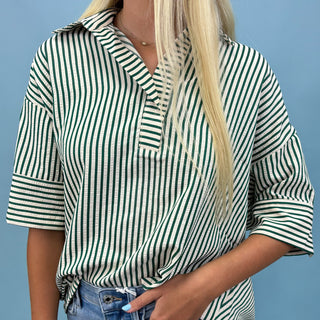 Person wearing a green and white striped shirt against a blue background