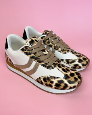 Leopard print sneakers with white soles on a pink background