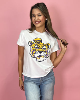 Woman wearing a white t-shirt with a tiger logo on a pink background