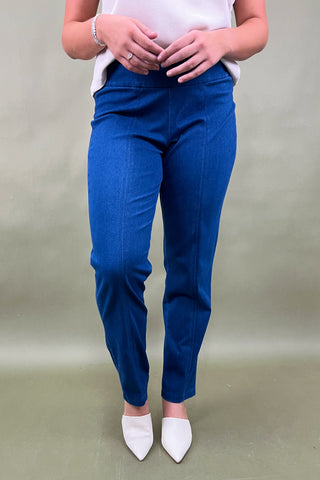 Person wearing blue pants and white shoes on a plain background