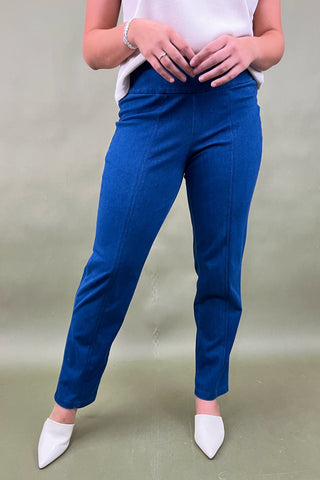 Person wearing blue pants and white shoes on a plain background