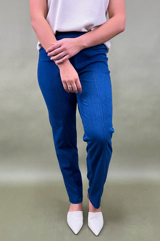 Person wearing blue pants and white shoes on a plain background