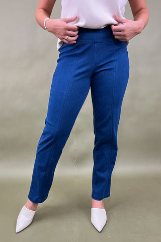 Person wearing blue pants and white shoes on a plain background
