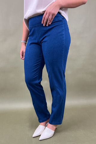 Person wearing blue pants and white shoes on a plain background