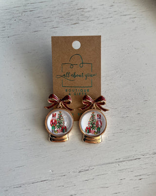 Shop the Christmas Nutcracker Snow Globe Bow Earrings at All About You Boutique! Festive red glitter bows and charming Christmas snow globe designs.