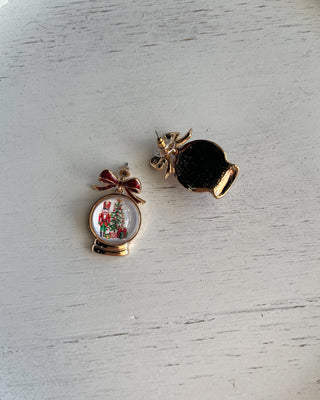 Shop the Christmas Nutcracker Snow Globe Bow Earrings at All About You Boutique! Festive red glitter bows and charming Christmas snow globe designs.