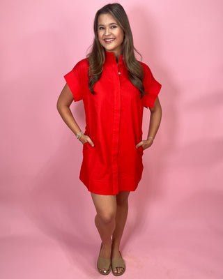 Woman wearing a red dress against a pink background