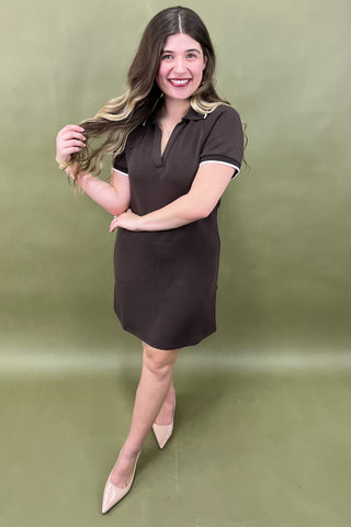 Woman wearing a brown dress against a green background